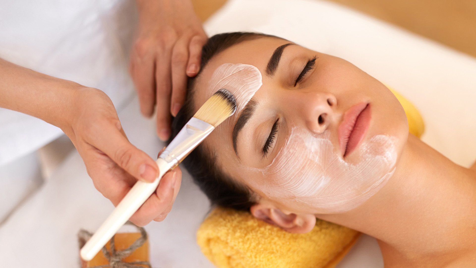 a woman getting a facial mask