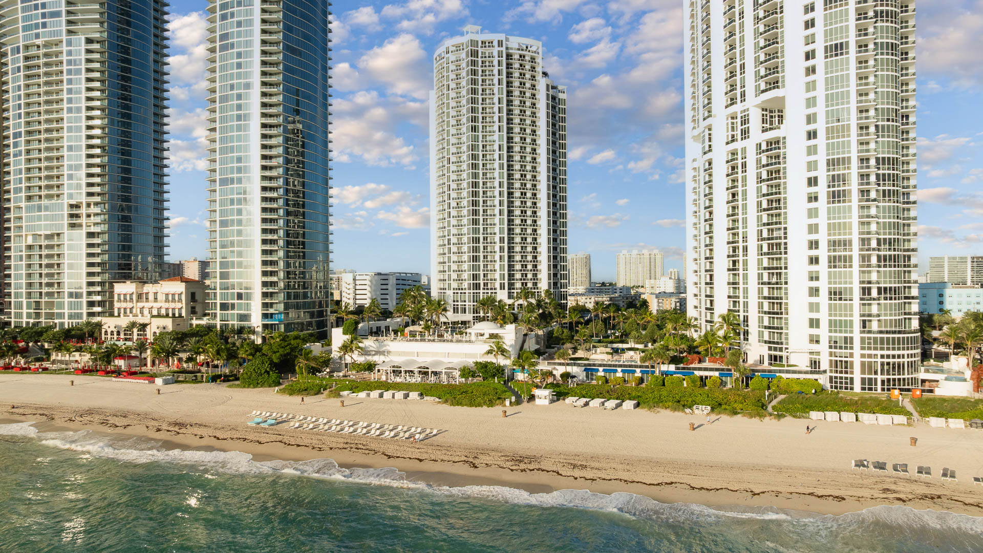 a beach with tall buildings and a body of water