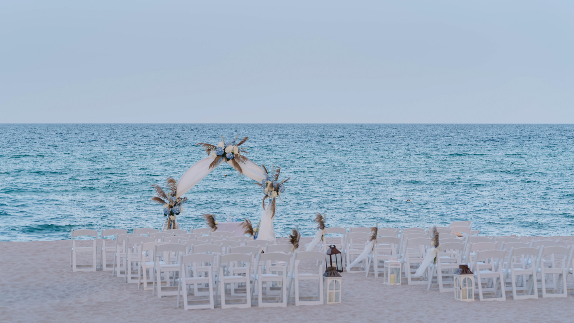 a beach wedding set up with chairs and a large body of water