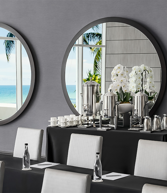 a table with a mirror and a vase of flowers