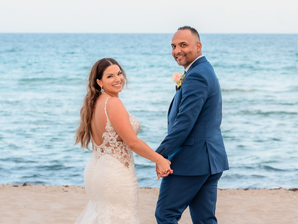 a man and woman holding hands on a beach