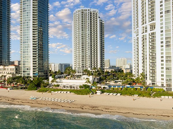 a beach with tall buildings and a body of water