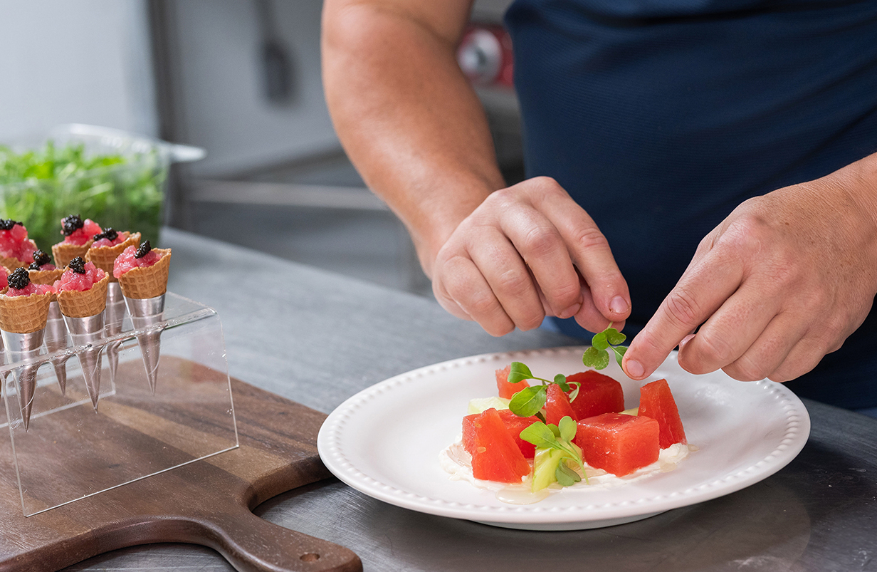 a person decorating food on a plate