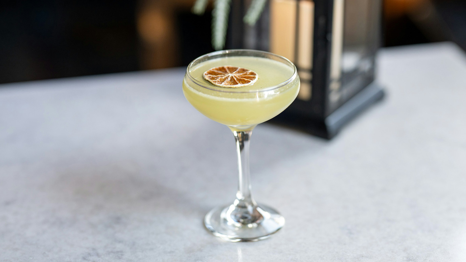 a glass with a drink and a slice of lemon on it