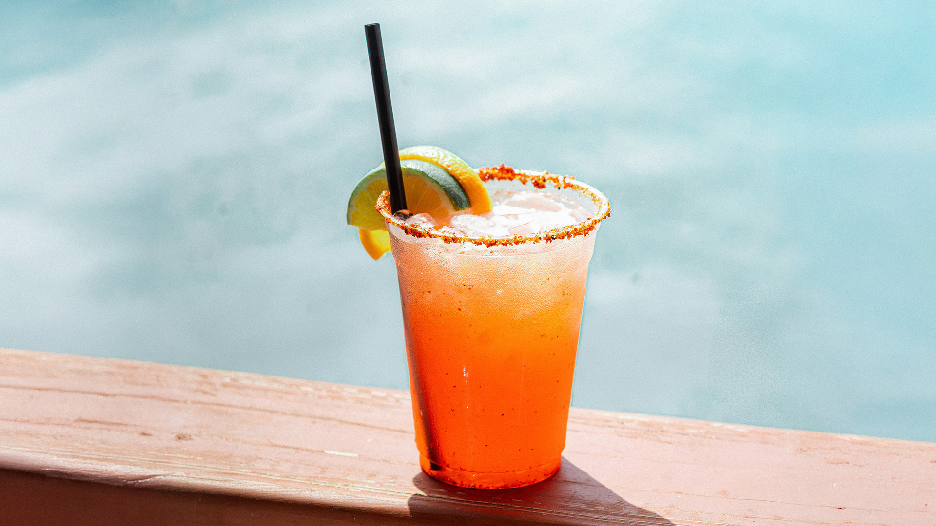 a drink with orange liquid and lime slices