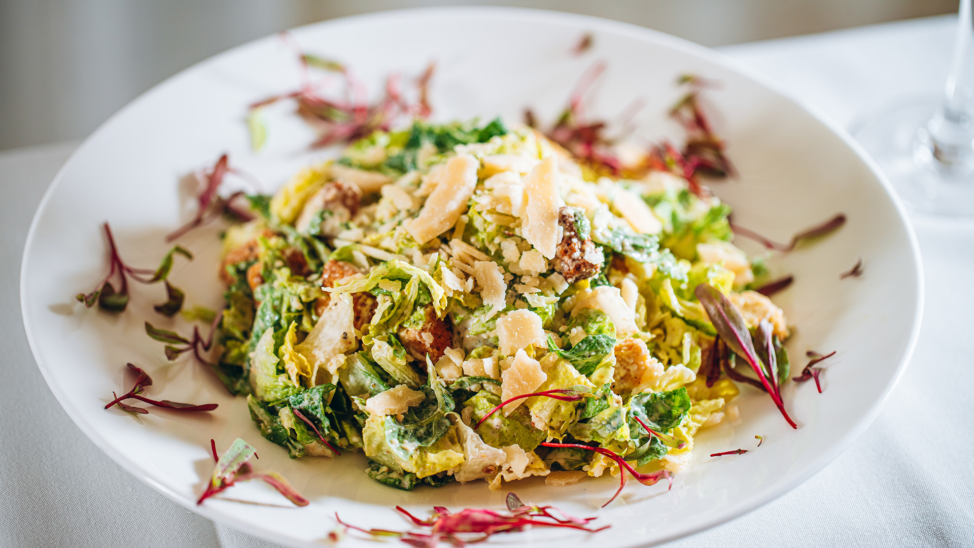 a plate of salad with cheese and vegetables