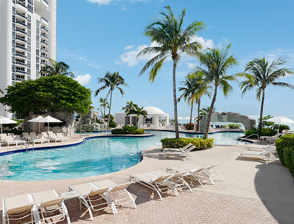a pool with lounge chairs and palm trees