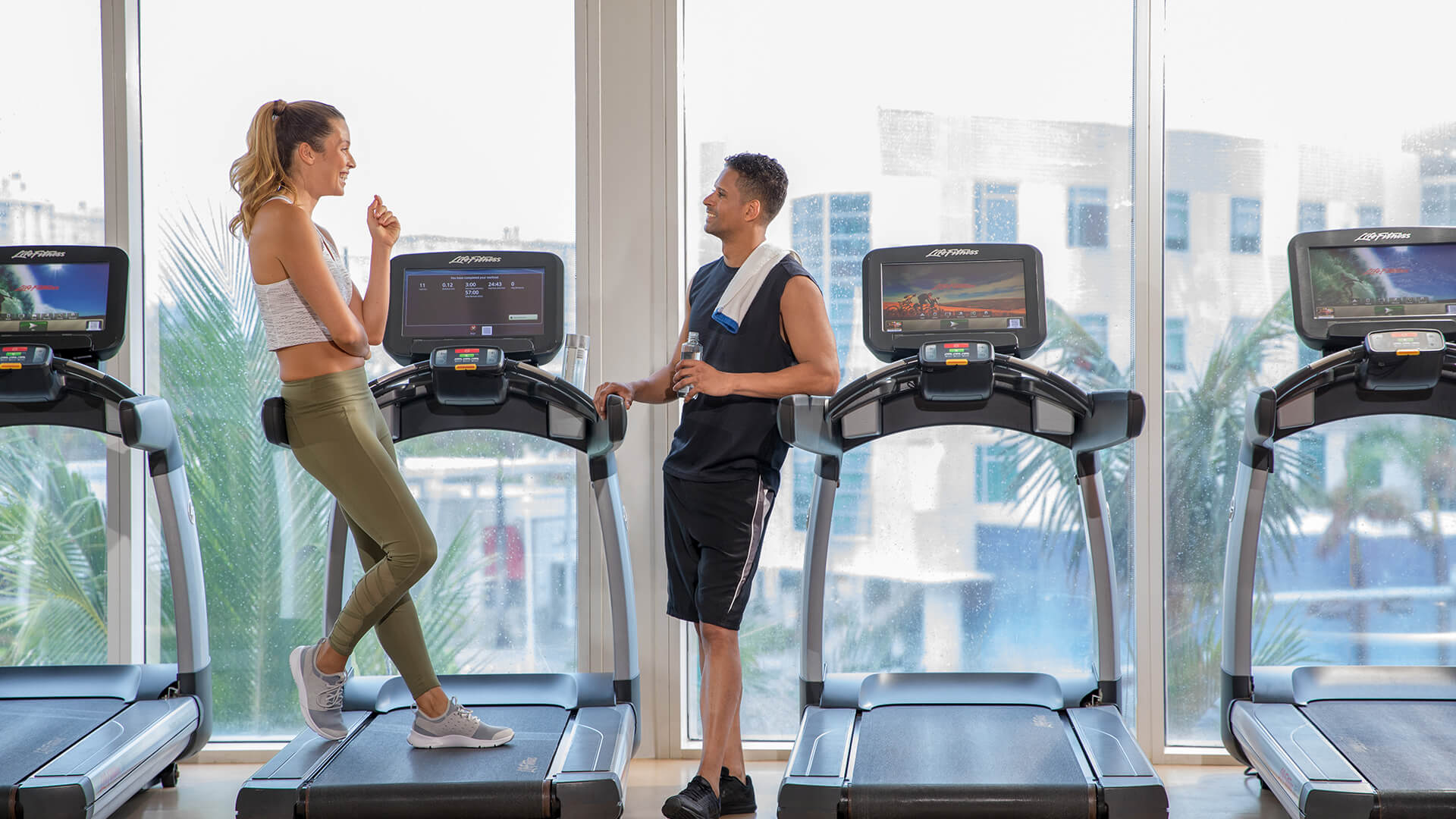 a man and woman standing on treadmills