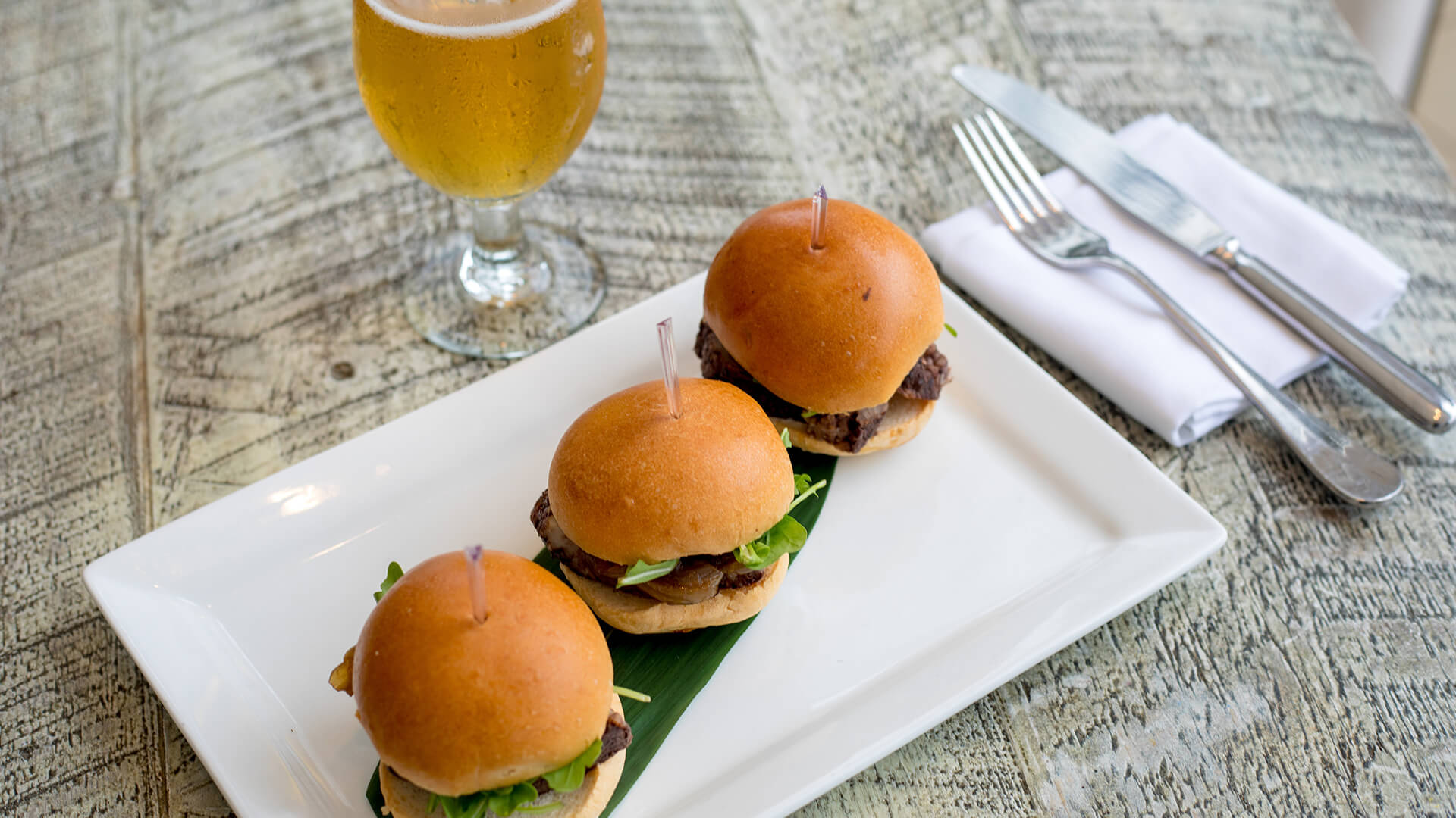 a plate of burgers and a glass of beer