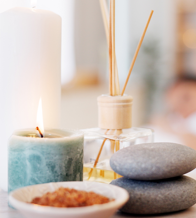 a candle and a candle with sticks next to a stack of rocks