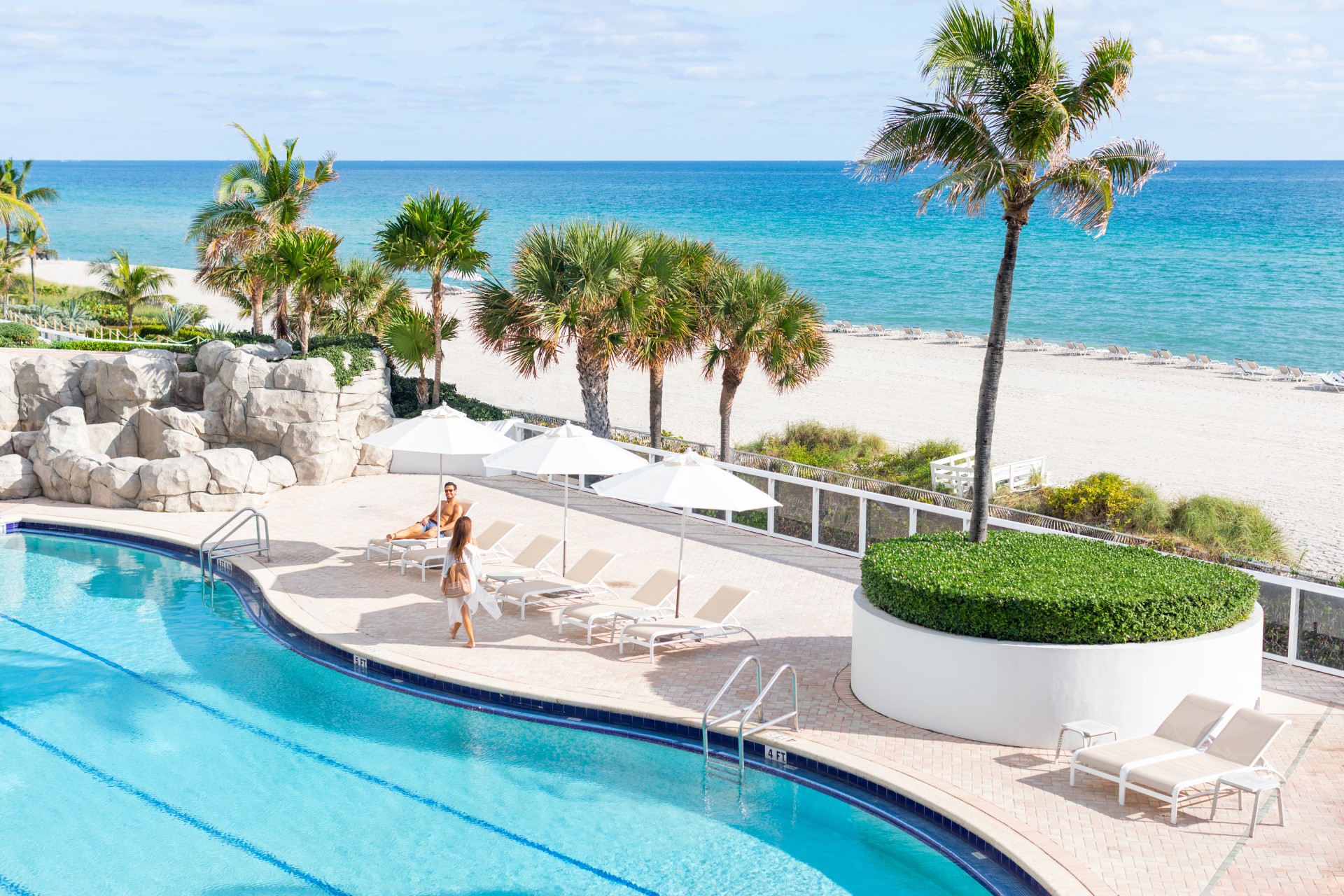 a pool with palm trees and a couple of people on it