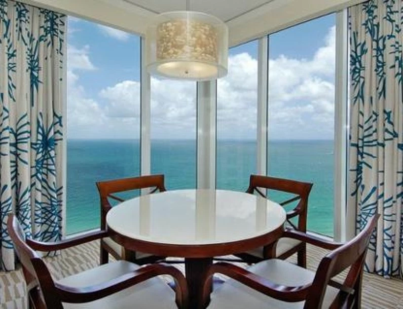 a table and chairs in a room with ocean view
