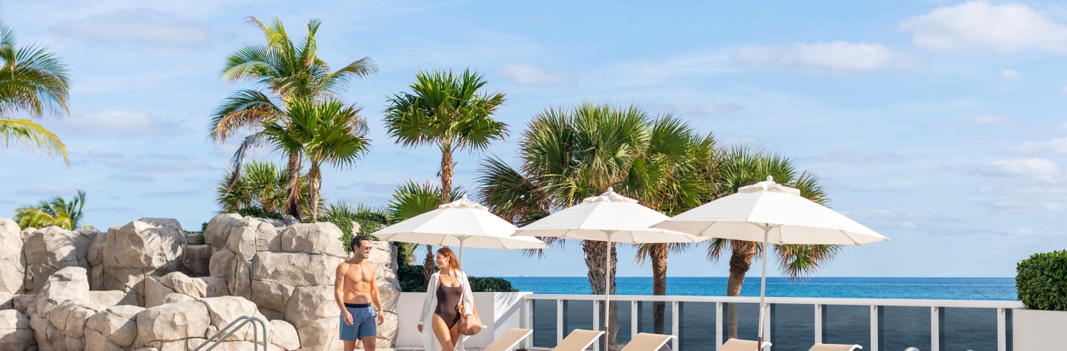 a group of people standing next to a pool