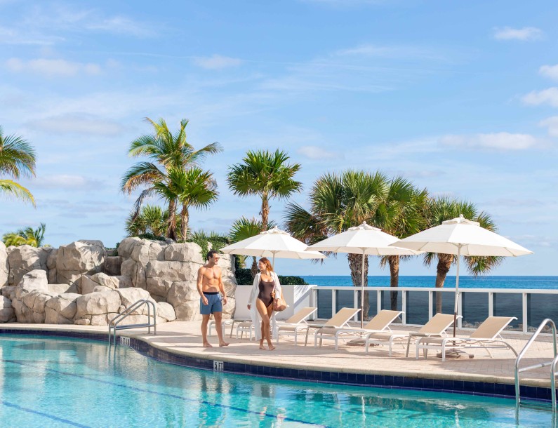 a group of people standing next to a pool