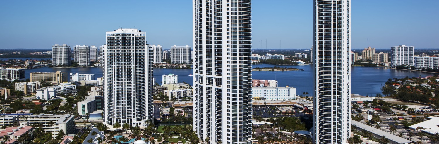 a group of tall buildings next to a beach