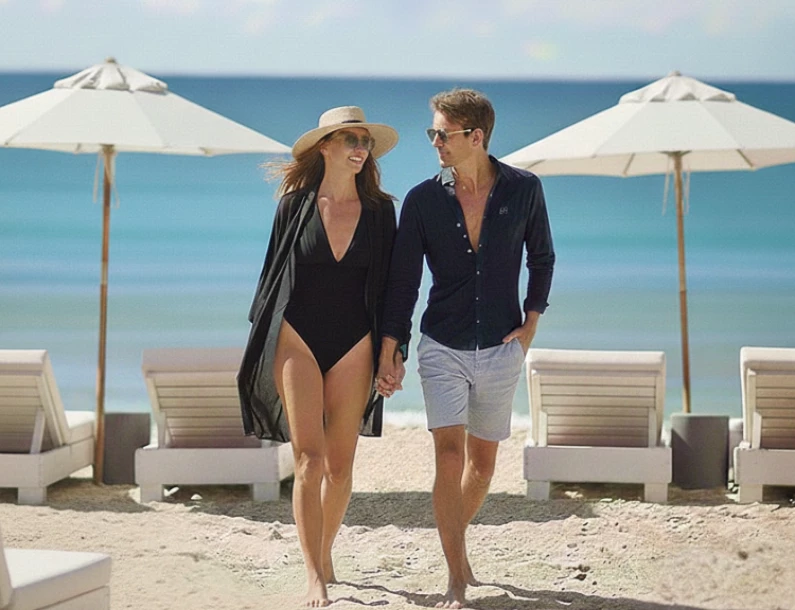 a man and woman walking on a beach