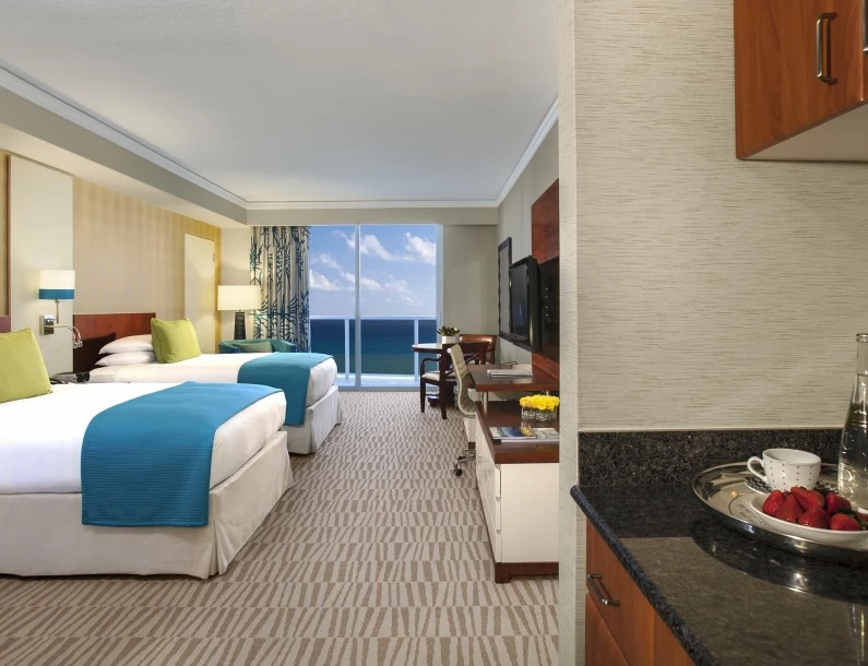 a hotel room with a large window overlooking the ocean