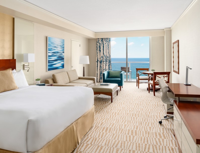 a room with a large bed and a desk and chairs