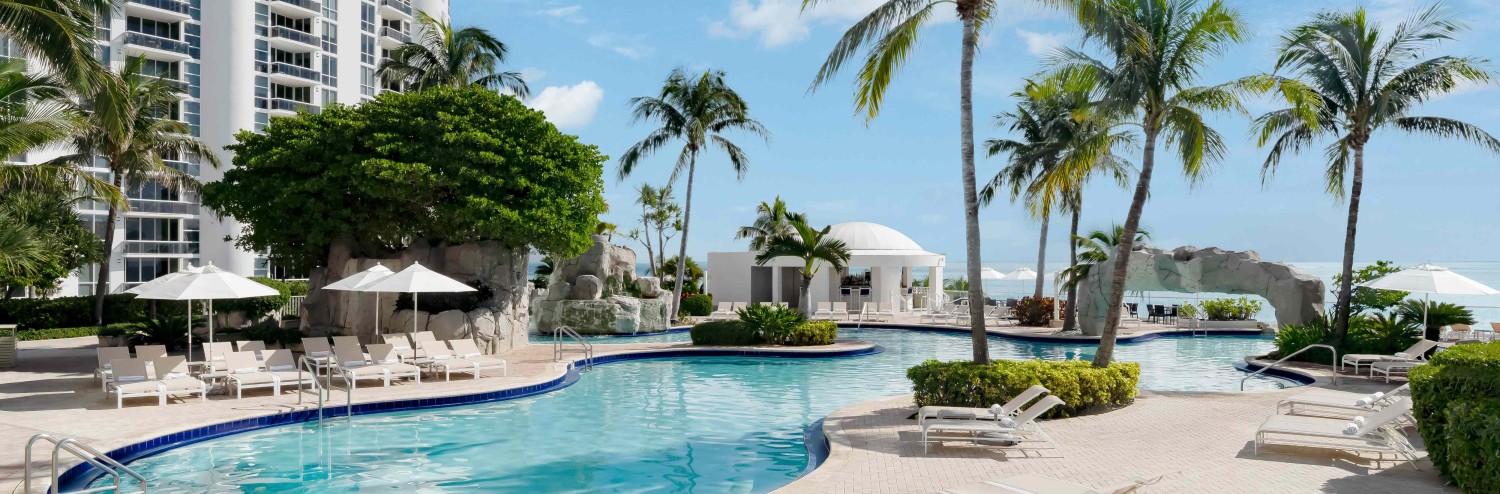 a pool with lounge chairs and palm trees