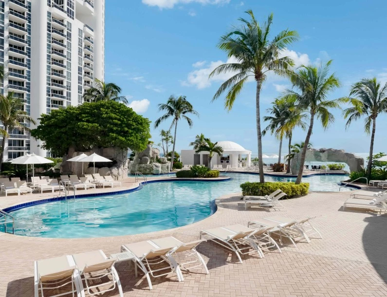 a pool with lounge chairs and palm trees