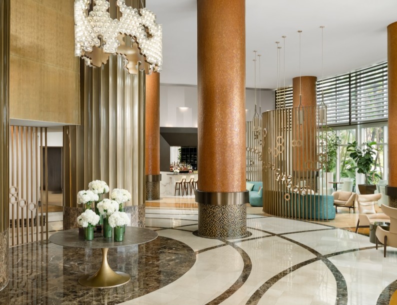 a large marble floor with columns and a chandelier
