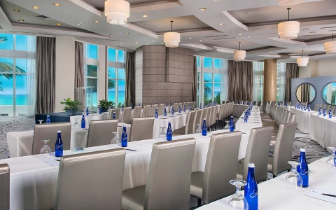 a large conference room with floor to ceiling windows overlooking the beach