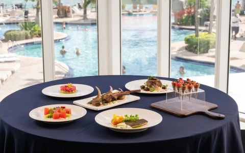 a table with plates of food and a pool in the background