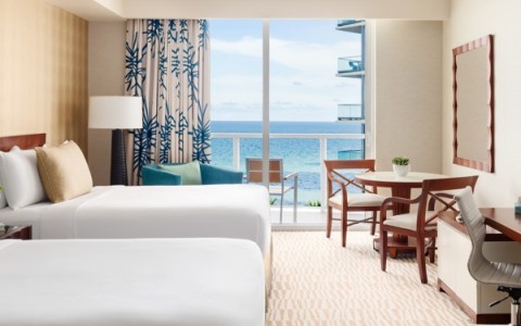 a room with two beds and a table and chairs