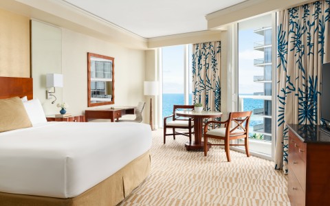 a room with a bed and chairs and a table