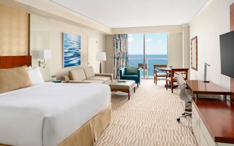 a room with a large bed and a desk and chairs