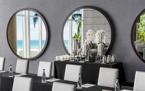 a table with a mirror and chairs