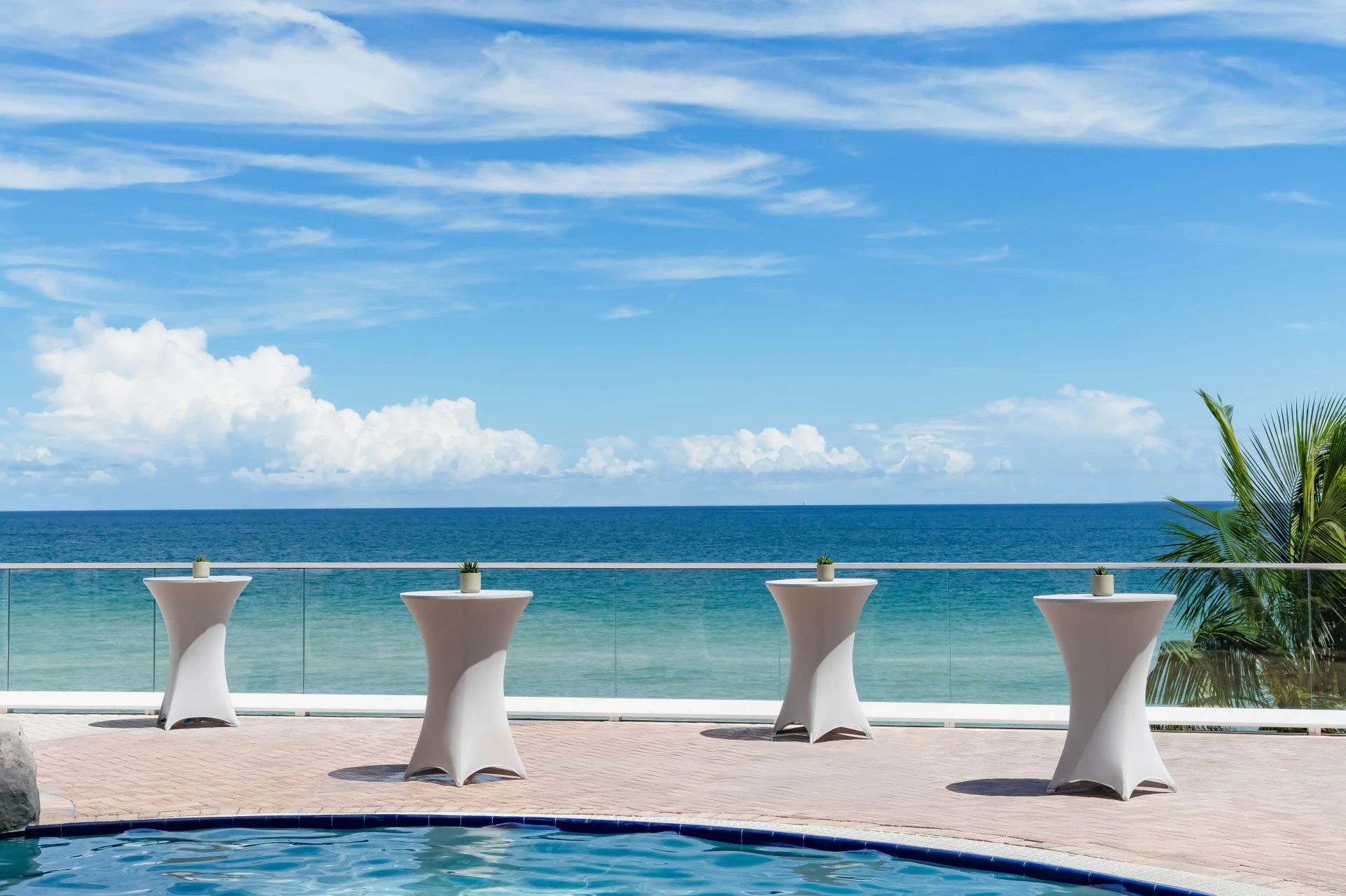 a group of tables on a patio overlooking a body of water