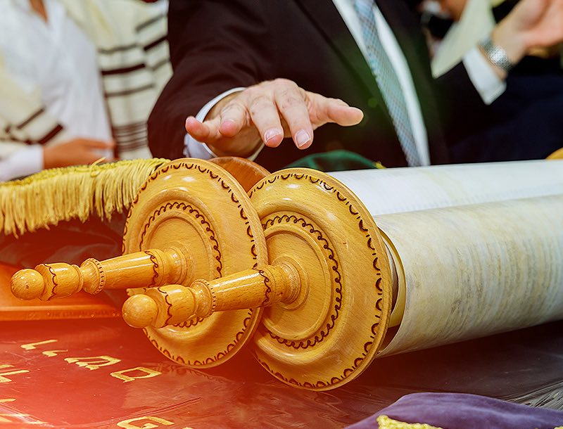a man's hand reaching out to a scroll of paper