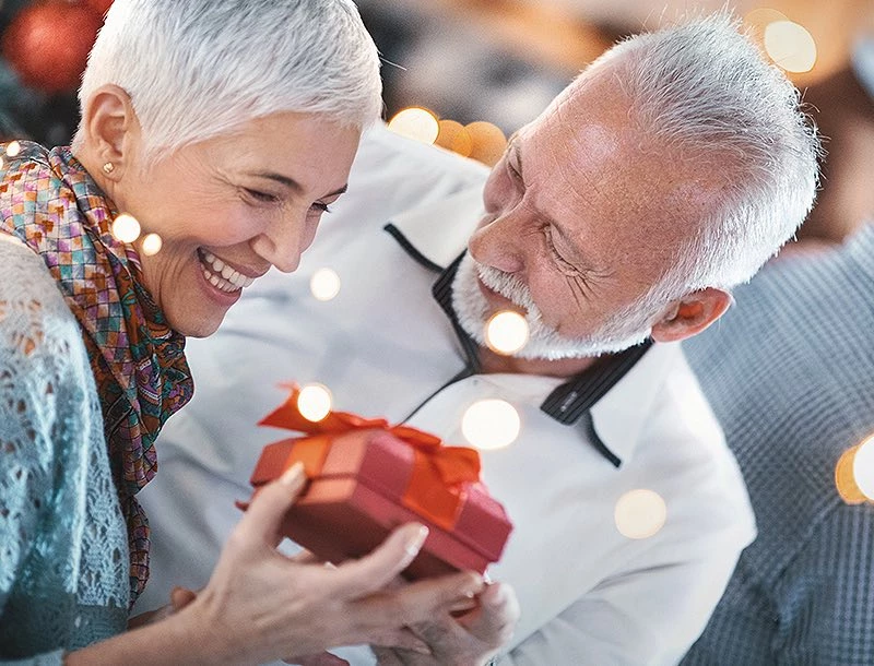 a man and woman holding a gift