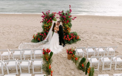a man and woman kissing on a beach