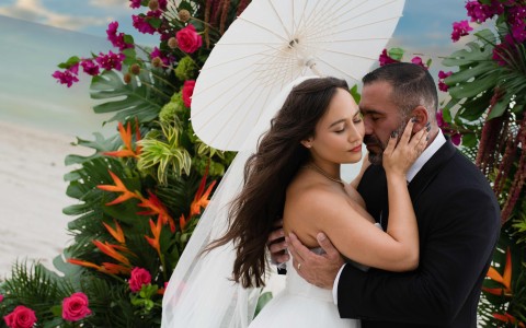 a man and woman kissing in front of flowers