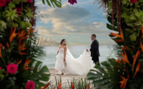 a bride and groom walking on a beach
