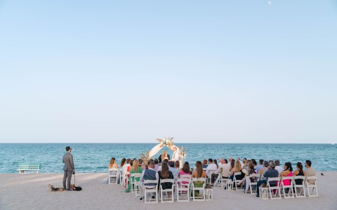 a group of people sitting in chairs on a beach