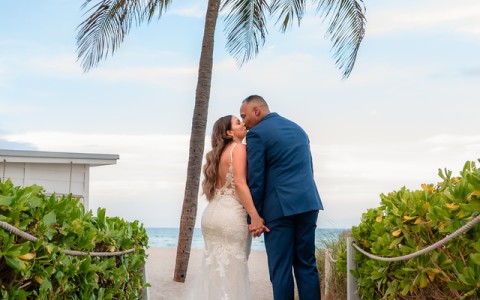 a man and woman kissing on a beach