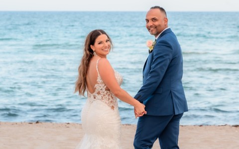 a man and woman holding hands on a beach