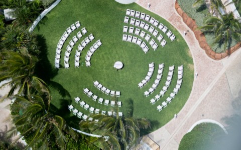an aerial view of a circular area with chairs and palm trees