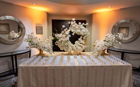 a table with white flowers and name cards