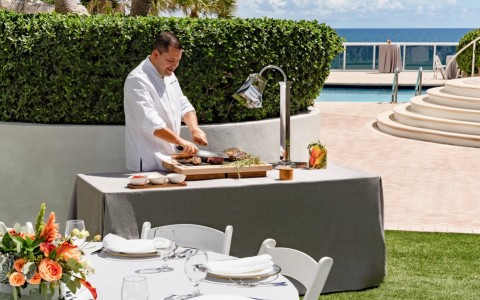 a man cutting meat on a table
