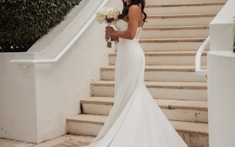 a woman in a wedding dress holding a bouquet of flowers