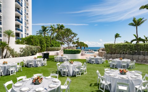 a group of tables and chairs outside with a building in the background
