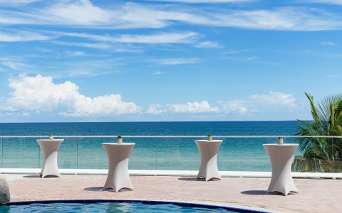 a group of tables on a patio overlooking a body of water