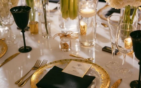 a table with a plate of gold plates and candles