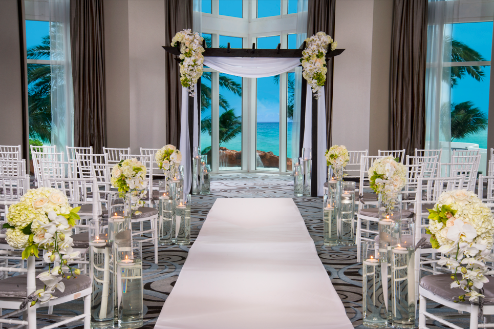 a wedding ceremony with white chairs and flowers