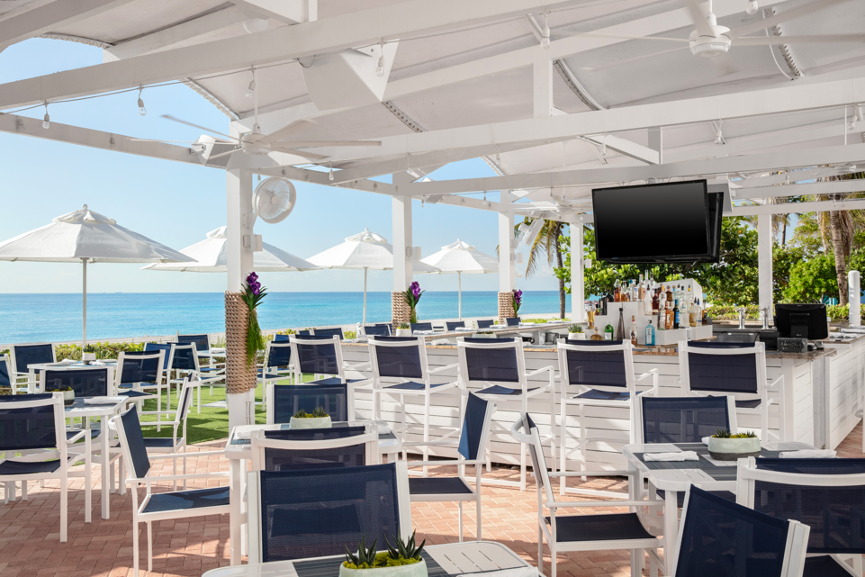 a white patio with chairs and umbrellas