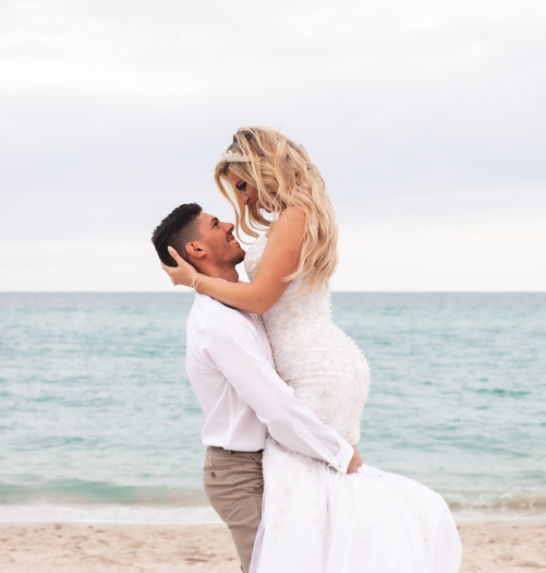 a man and woman in wedding attire on a beach